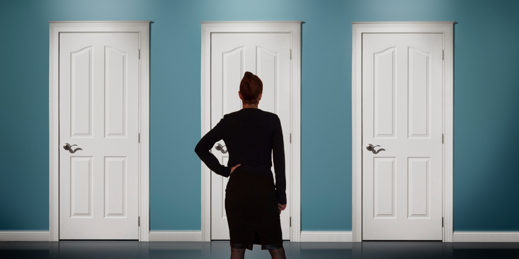 Woman stands in front of three doors