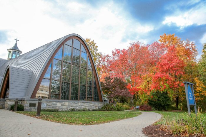 building with a glass front in amongst trees in fall
