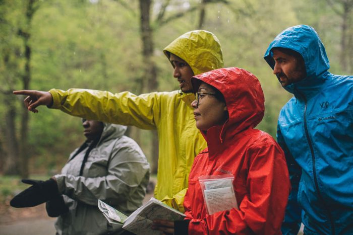 four people dressed in raincoats in a forest