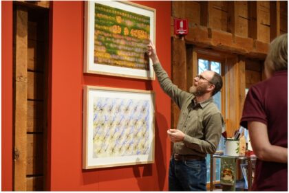 Man pointing at art work on a wall