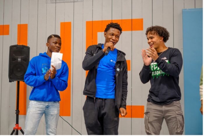 Three young men presenting on stage 