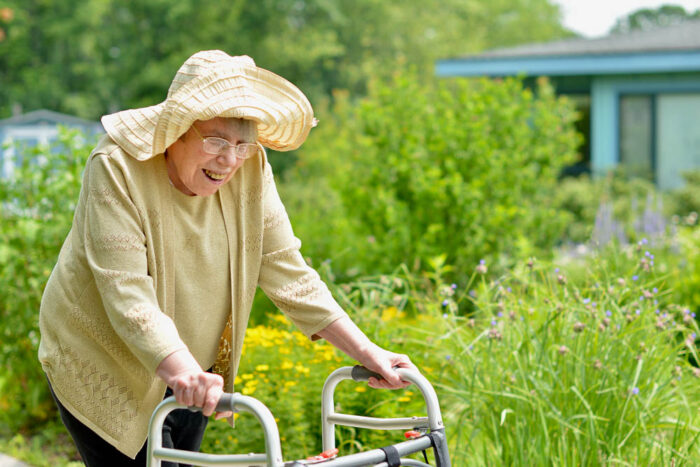 an elderly woman using a walker to get around camphill village