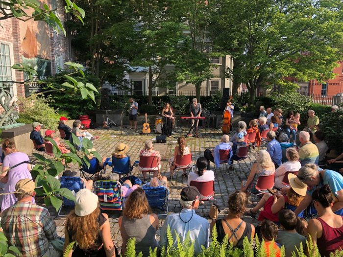 group of people watching an outdoor performance at cape ann museum