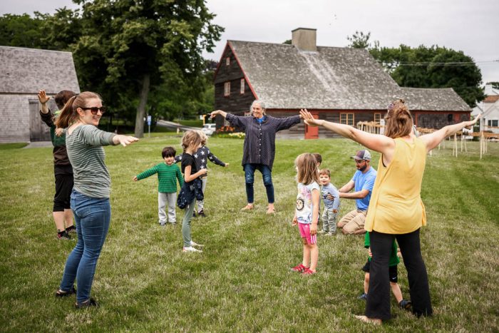 families with young children dancing on lawn at cape ann museum