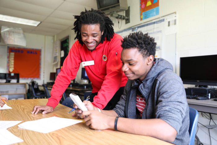 city year volunteer helping a student with work