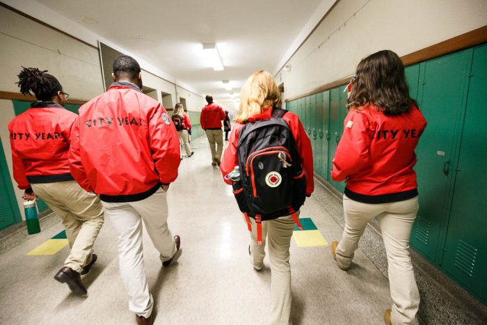 city year volunteers walking down a school hallway