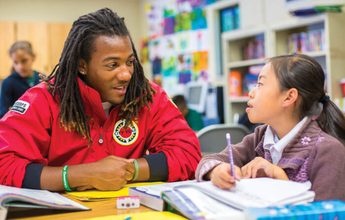 CIty Year volunteer working with a child on school work
