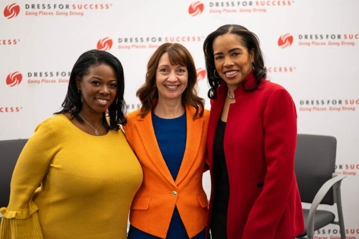 three women posing together at a dress for success event