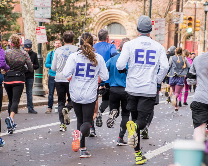two people in a marathon with emily's entourage shirts