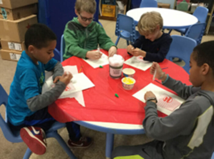 children coloring at a table at the Haverhill Public Lirbary