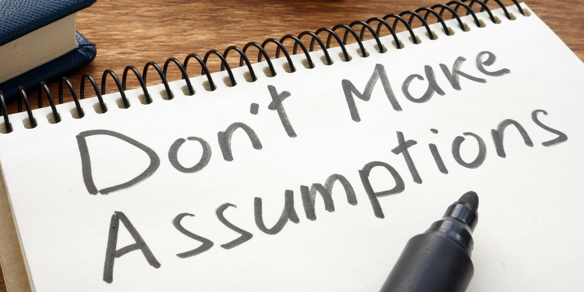 Notepad with "Don't Make Assumptions" written on it