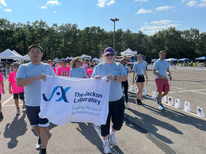 group of runners holding a sign with Jackson Laboratory's logo