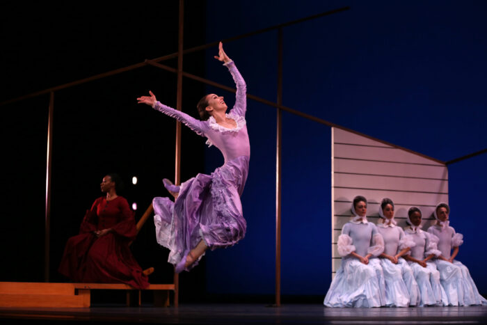 Woman dancing on stage in purple dress
