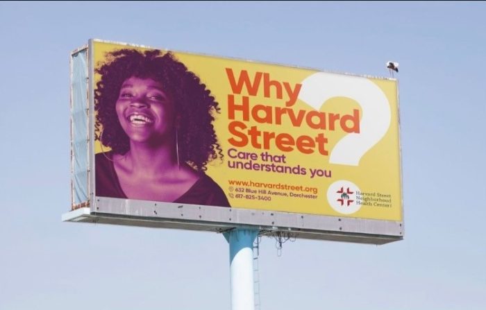 woman on a billboard that reads why harvard street