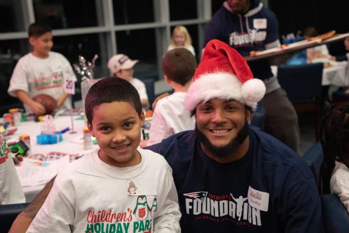 a young man wearing a santa hat and child posing for the camera