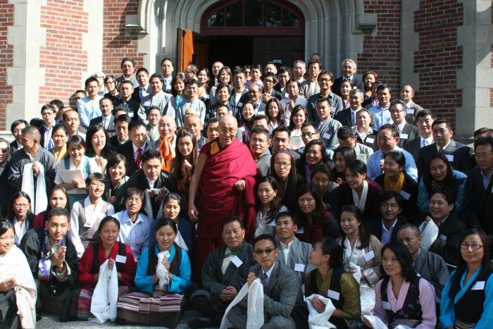 a group of people posing with the dalai lama