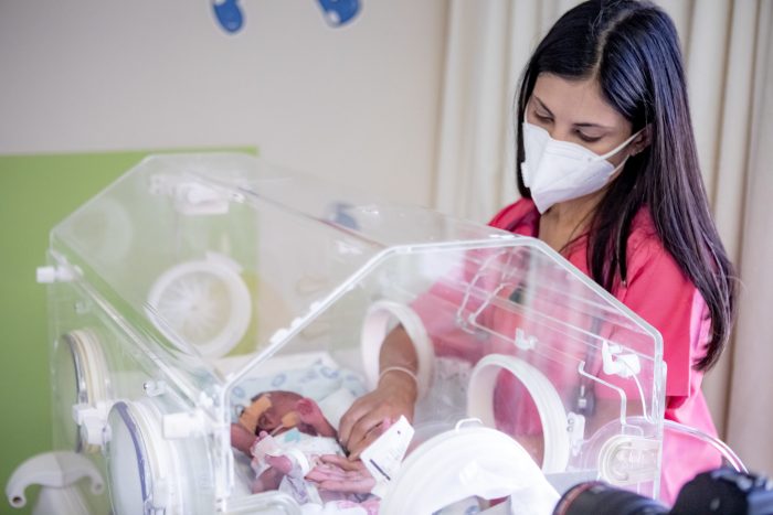 woman caring for a baby in an incubator