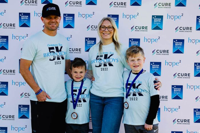 a family of four wearing cure rare disease shirts